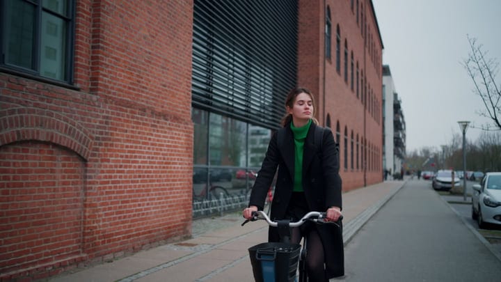 Confident Morning Ride Through Copenhagen's Brick-Lined Streets