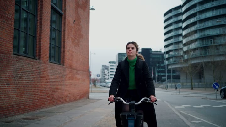 Confident Cyclist Navigates Copenhagen's Urban Landscape
