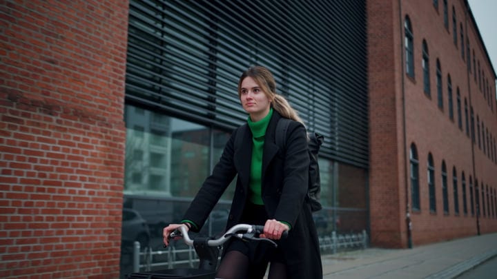 Confident Businesswoman Cycling Through Copenhagen Streets