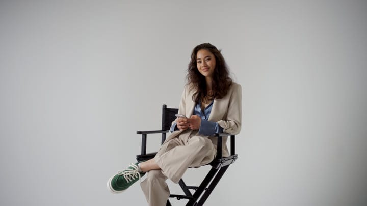 Confident Woman Relaxing In Studio With Casual Elegance