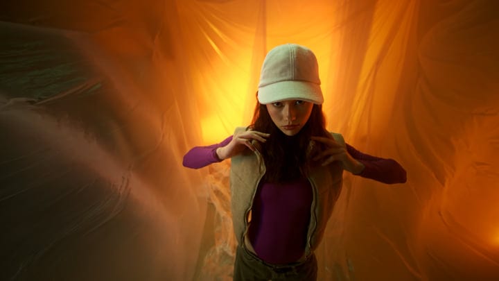 A Fashion Model Posing Against a Warm Golden Backdrop