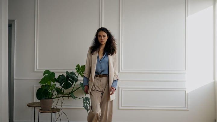 Confident Woman in Neutral Suit Walks Through Minimalist Studio