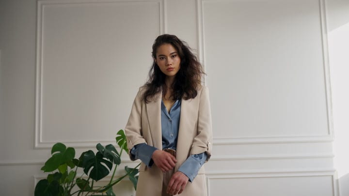 Elegant Woman In Beige Blazer In Minimalist Studio