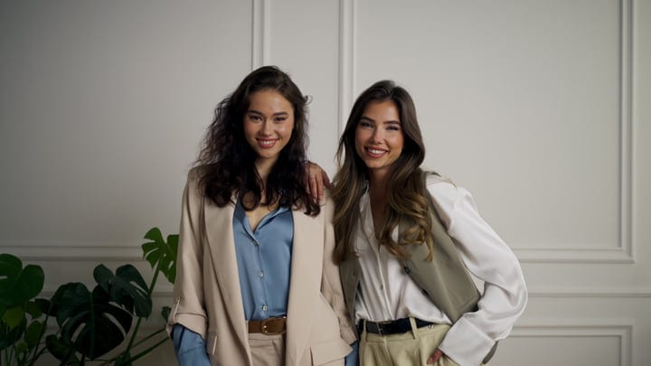 Two Friends Embrace Stylishly in a Bright Studio Setting
