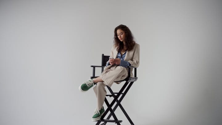 Thoughtful Woman in Stylish Suit Seated in Studio Chair