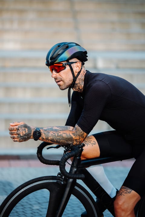 Tattooed Cyclist Powers Through City Streets At Dawn