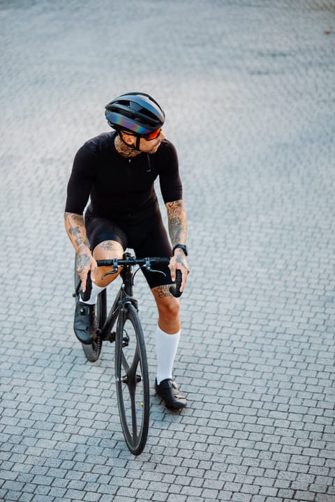 Tattooed Cyclist Navigates Through City Streets Confidently