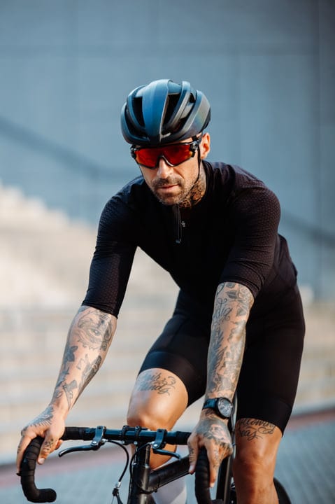 Tattooed Cyclist Powers Through Urban Streets At Dawn