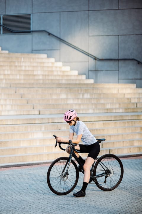 Cyclist Pauses To Check Her Route In The City