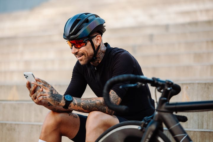 Cyclist Takes A Break To Check Messages On City Steps