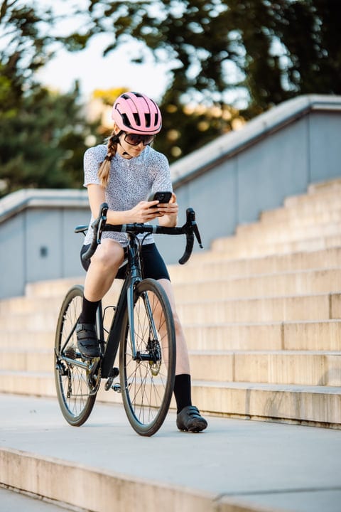 Cyclist Pauses To Check Her Phone In The City