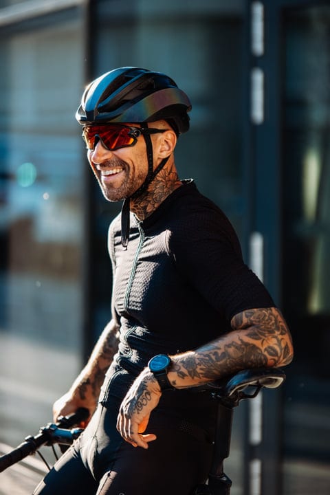 Tattooed Cyclist Embraces Urban Adventure in Sunlight
