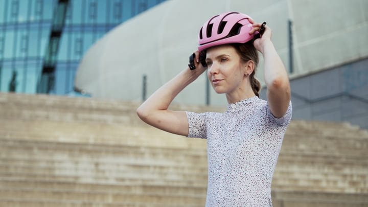Confident Cyclist Adjusts Helmet Before Urban Adventure