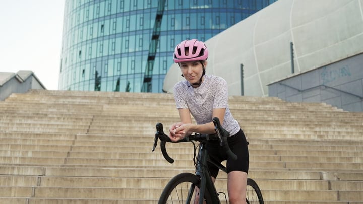 Urban Cyclist Pauses on City Steps with Modern Backdrop