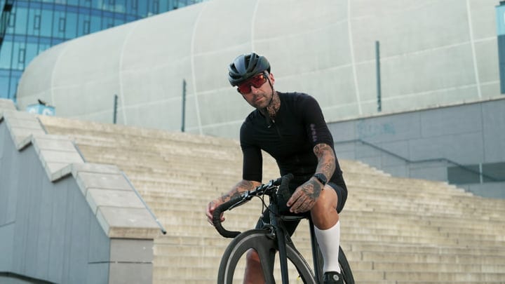 Urban Cyclist Pauses By Modern Architecture Steps