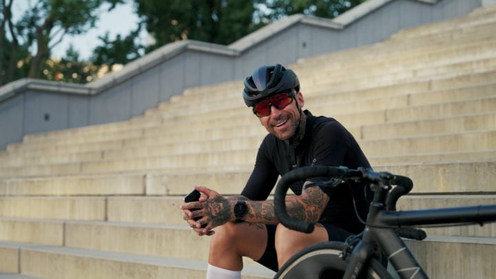 Cyclist Takes A Break On City Steps With A Smile