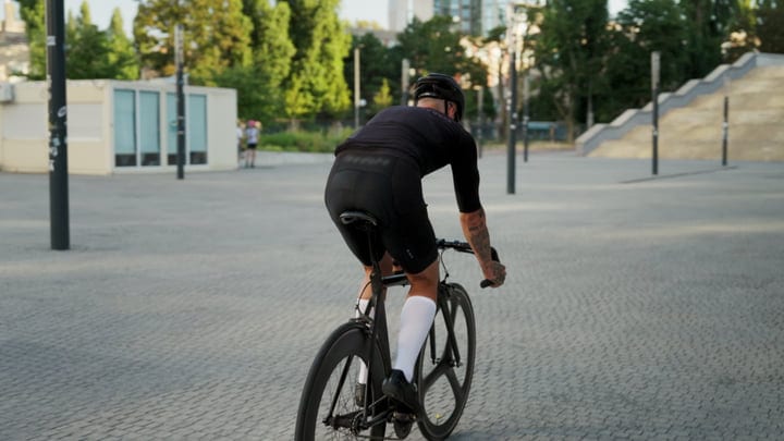 Cyclist Navigates City Streets In Early Morning Light