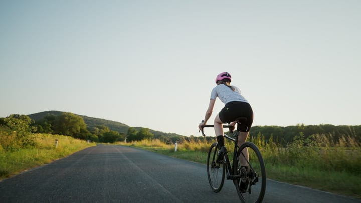 Cyclist Embraces The Open Road At Dusk