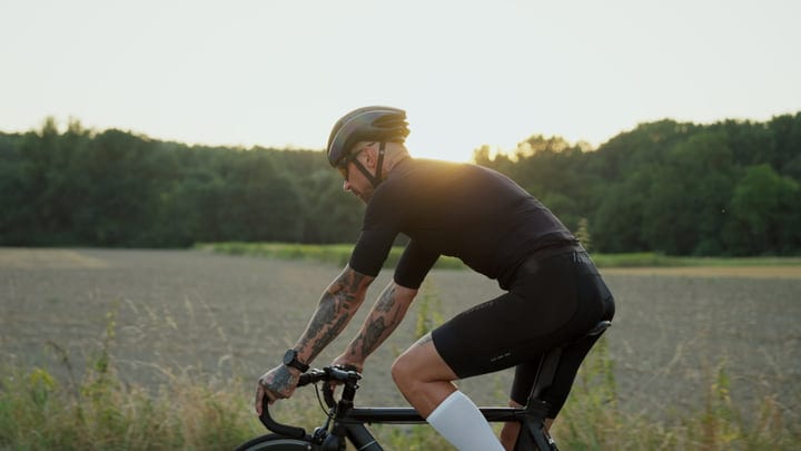 Cyclist in Motion Against a Serene Sunrise Background
