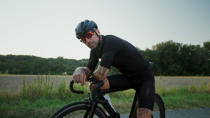 Urban Cyclist Pauses In Scenic Countryside Setting
