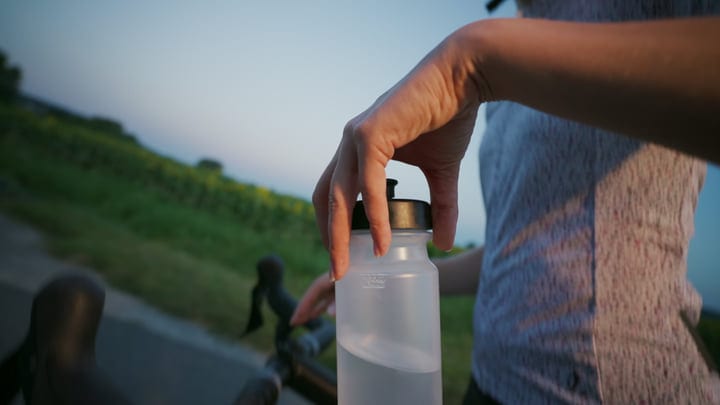 Cyclist Pauses to Hydrate on a Sunny City Ride