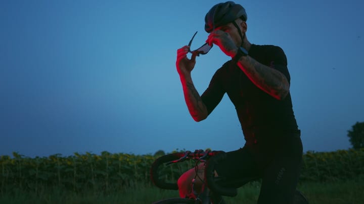 Cyclist Adjusts Sunglasses At Dusk Among Sunflowers
