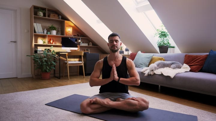 Man Embraces Tranquility With Meditation At Home