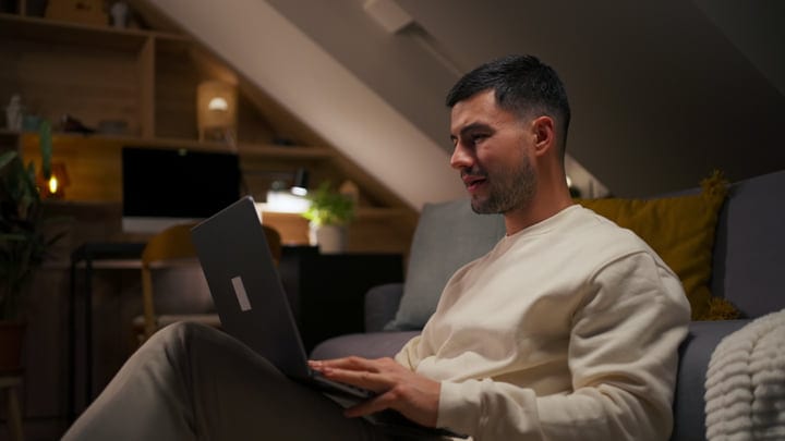 Focused Man Enjoying Remote Work In Cozy Attic Space