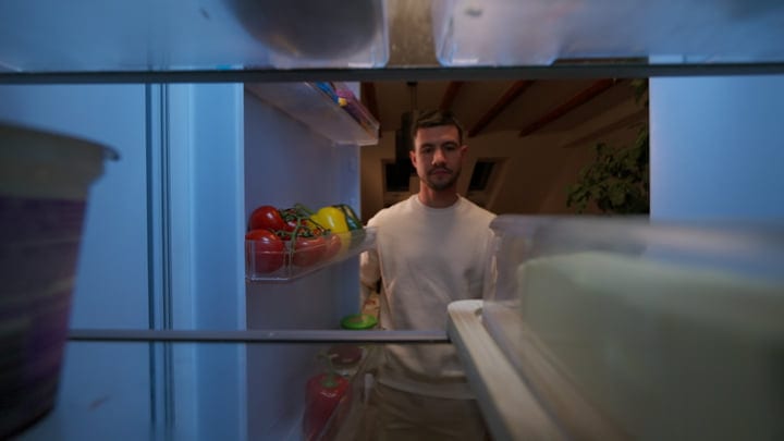 Evening Reflections: Man Contemplating Choices From Fridge