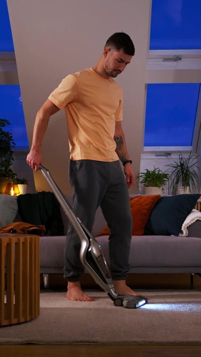 Evening Cleanup: A Man Vacuums His Cozy Living Room