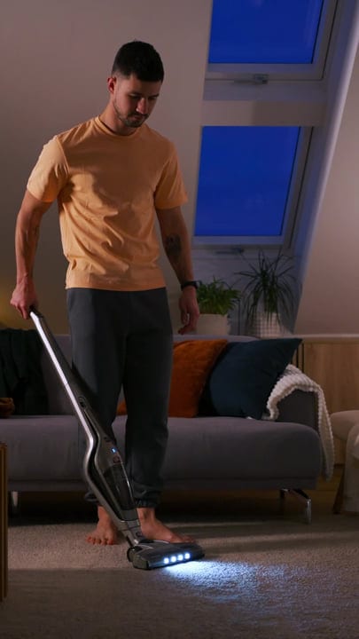Man Cleans His Living Room While Working From Home