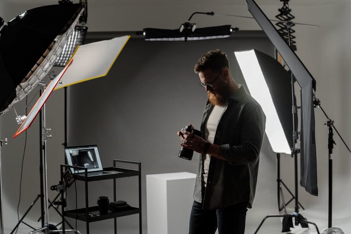 Creative Focus: Photographer Adjusting Camera Settings In Studio