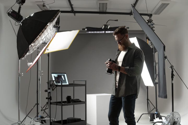 Focused Photographer Adjusts Camera Settings in Modern Studio