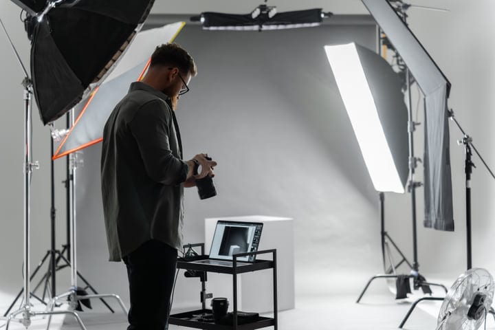 Focused Photographer Prepares Camera In Bright Studio
