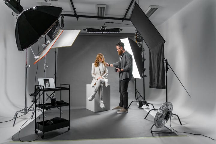Photographer Adjusts Lighting for Studio Portrait Session