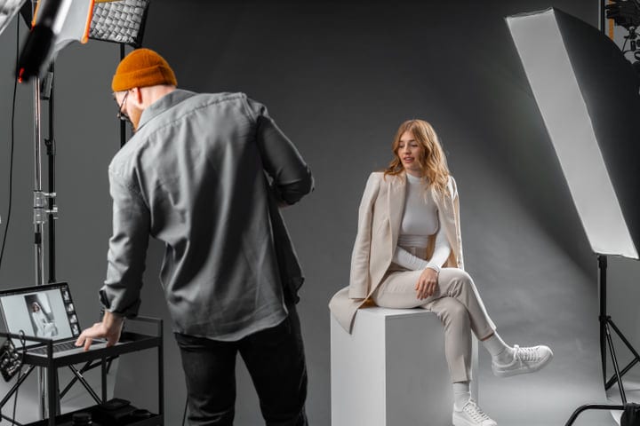 Photographer Adjusts Equipment While Model Awaits in Studio