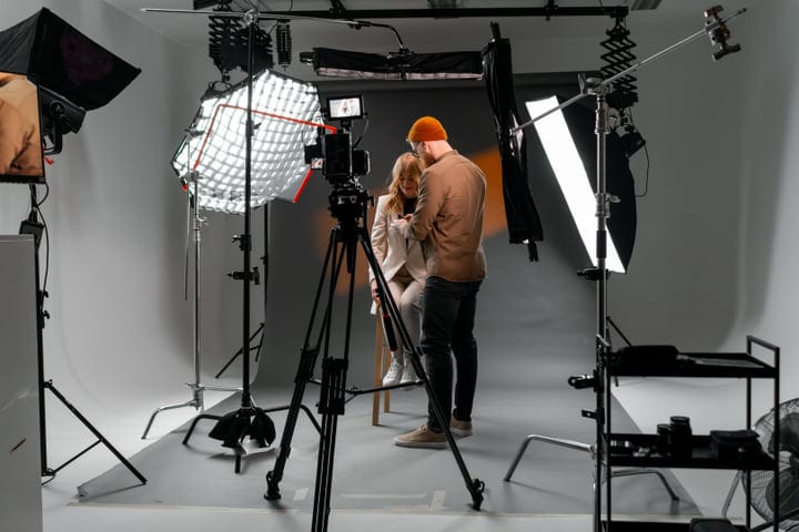 Photographer Adjusts Model's Pose Under Studio Lights