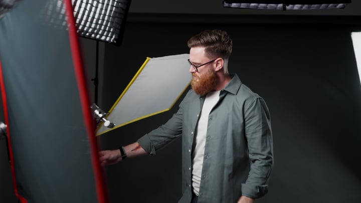 Creative Photographer Adjusts Studio Lighting Equipment