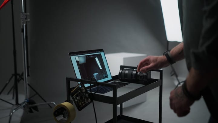 Photographer Adjusts Equipment In A Professional Studio Setup
