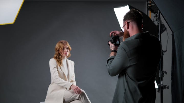 Capturing Elegance: Photographer Focused On Model In Studio