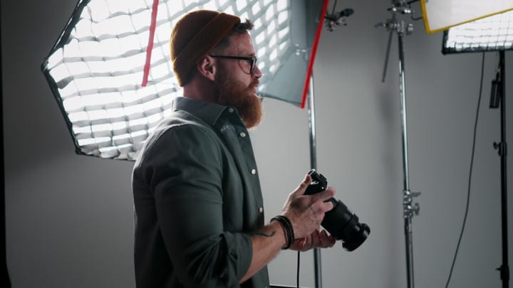 Focused Photographer Engages With Camera In Studio Setup