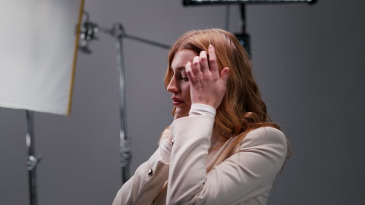 Woman Adjusts Hair In A Professional Studio Setting