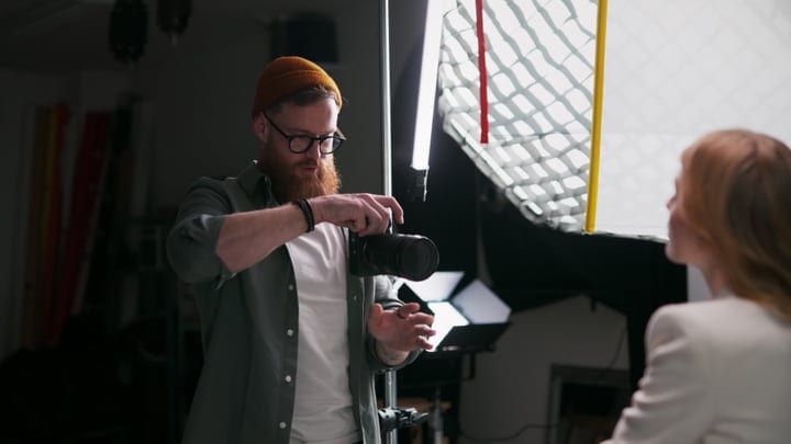 Creative Photographer Adjusts Camera In Modern Studio