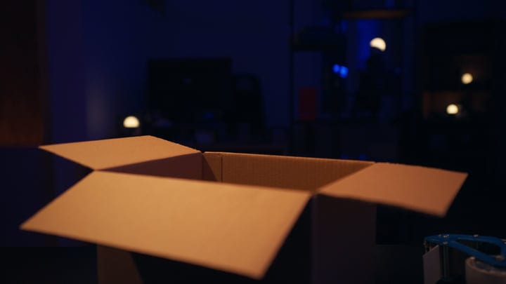 Cardboard Box Awaits in Dimly Lit Studio Setting