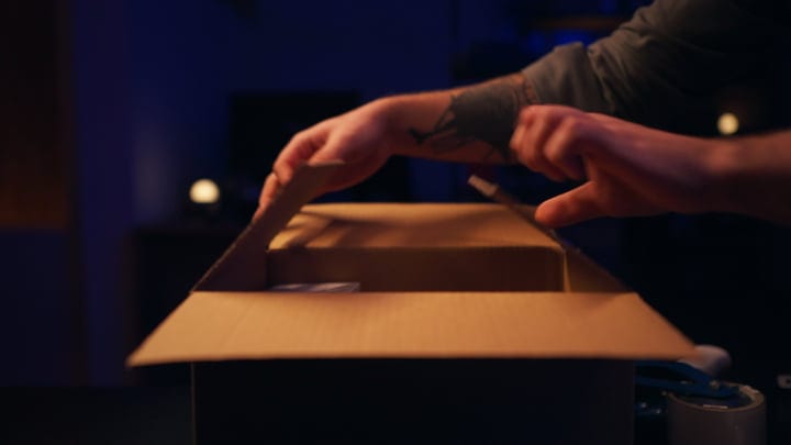 Hands Gently Unpack A Box In The Studio Glow