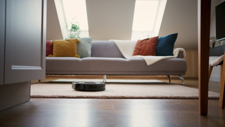 A Robot Vacuum Glides Across A Cozy Living Room