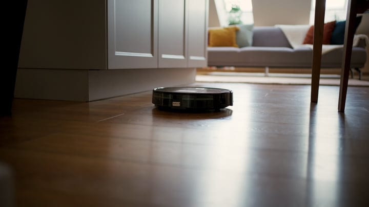 A Robot Vacuum Glides Across a Sunlit Living Room