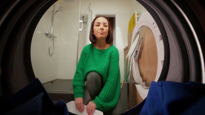 A Woman's Thoughtful Moment By The Washing Machine