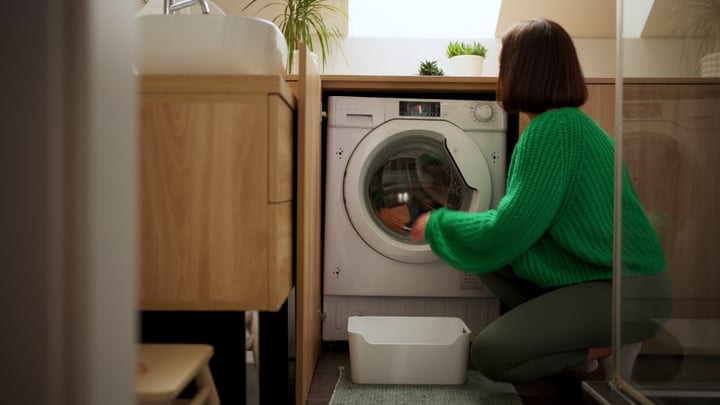 Woman Embraces Calm Laundry Ritual In Cozy Home