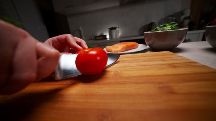 Slicing Fresh Tomatoes In A Cozy Kitchen Setting